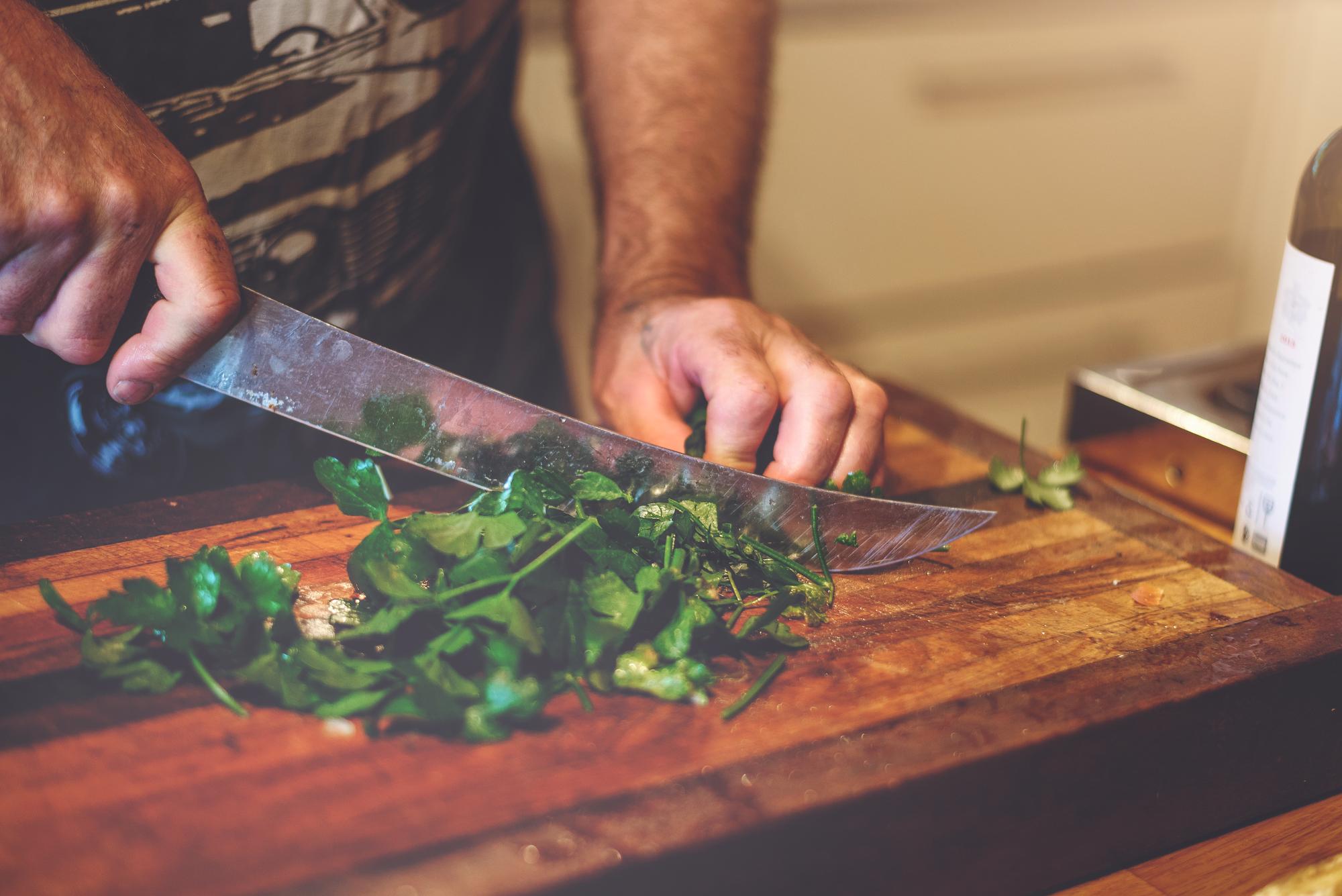 artisan chef arranging herbs on a wooden board